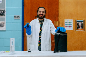 SPARK 2024. Arian Jadbabaie (in the lab coat), a postdoc in the Doyle group, demonstrates flux pinning in a YBCO superconductor to students at UP Academy Dorchester.