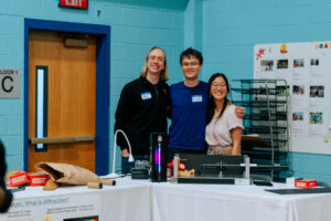 SPARK 2024. Alex Deters, Michal Szurek, and Annie Zhi from the Greiner group walk students through making holograms and spectroscopes.